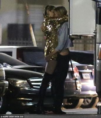 Miley Cyrus e Stella Maxwell se beijando e batendo os dedos