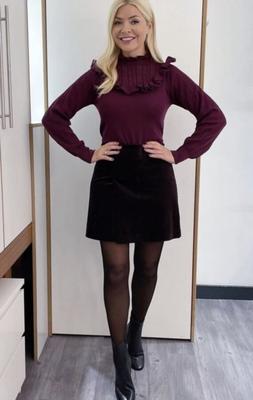 A gostosa Holly Willoughby de saia curta e meia-calça.